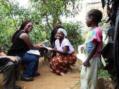Project Manager, Rebecca Machiya, delivers a loan check to a sponsored mother